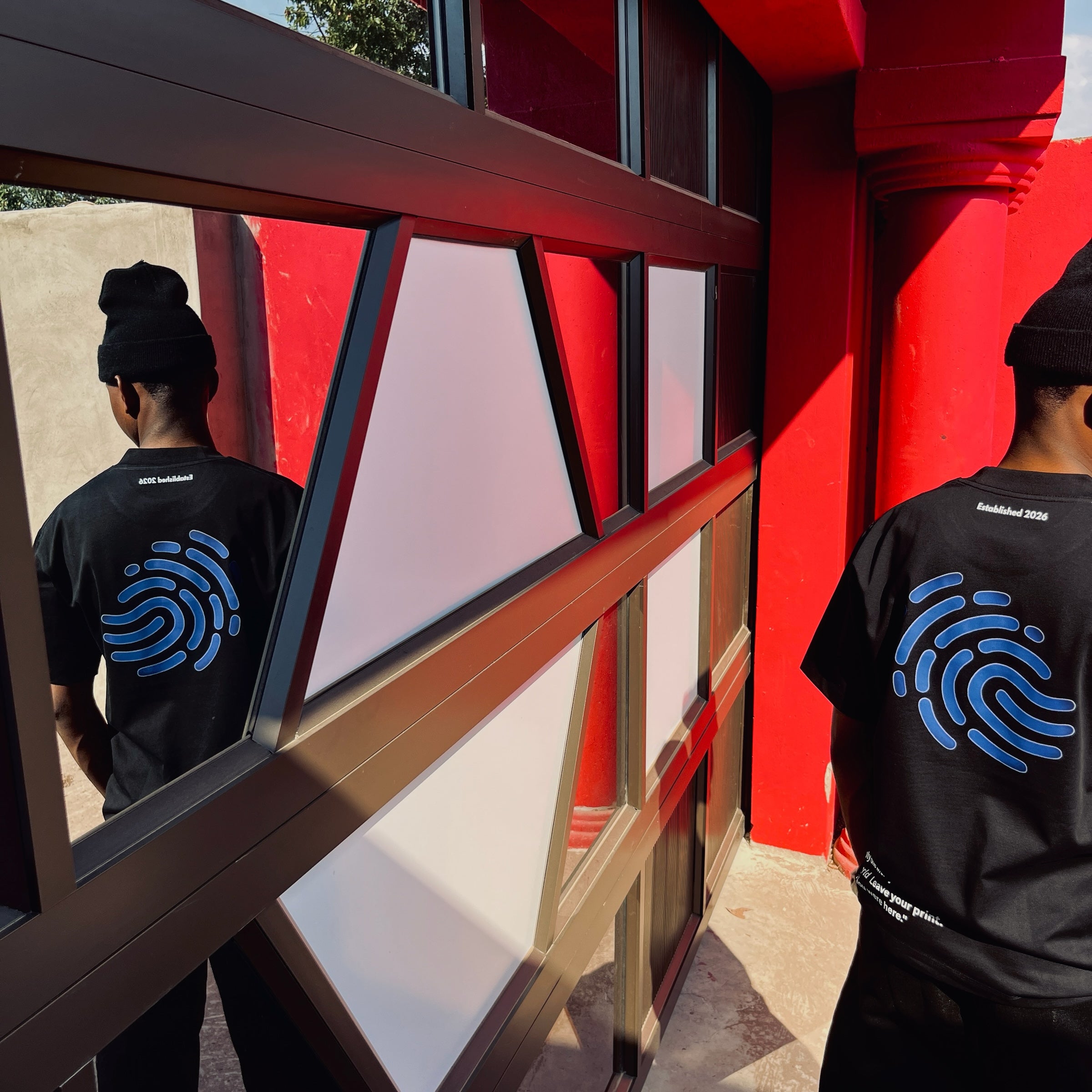 ZWENO.INC black cotton t-shirt with a blue fingerprint graphic on the back, worn by a model in a beanie.